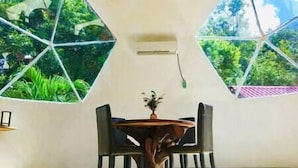A room with a hexagonal window design, a round table, and chairs. - Casa Leon Global, 3 Domes In Mayan Jungle (Cancún)