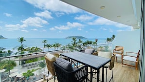 Un balcon avec vue sur l’océan et les palmiers.