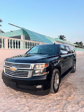 A black Chevrolet SUV parked on a sandy surface. - Luxury 4-bedroom home near the beach, with free transportation from the airport (Chelem)