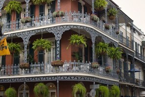 A multi-story building with ornate balconies, large windows, and hanging planters.