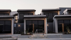 A modern building with large windows and a well-lit entrance. - VILLA SIMUL HOTEL BOUTIQUE VALLE DE GPE (Valle de Guadalupe)
