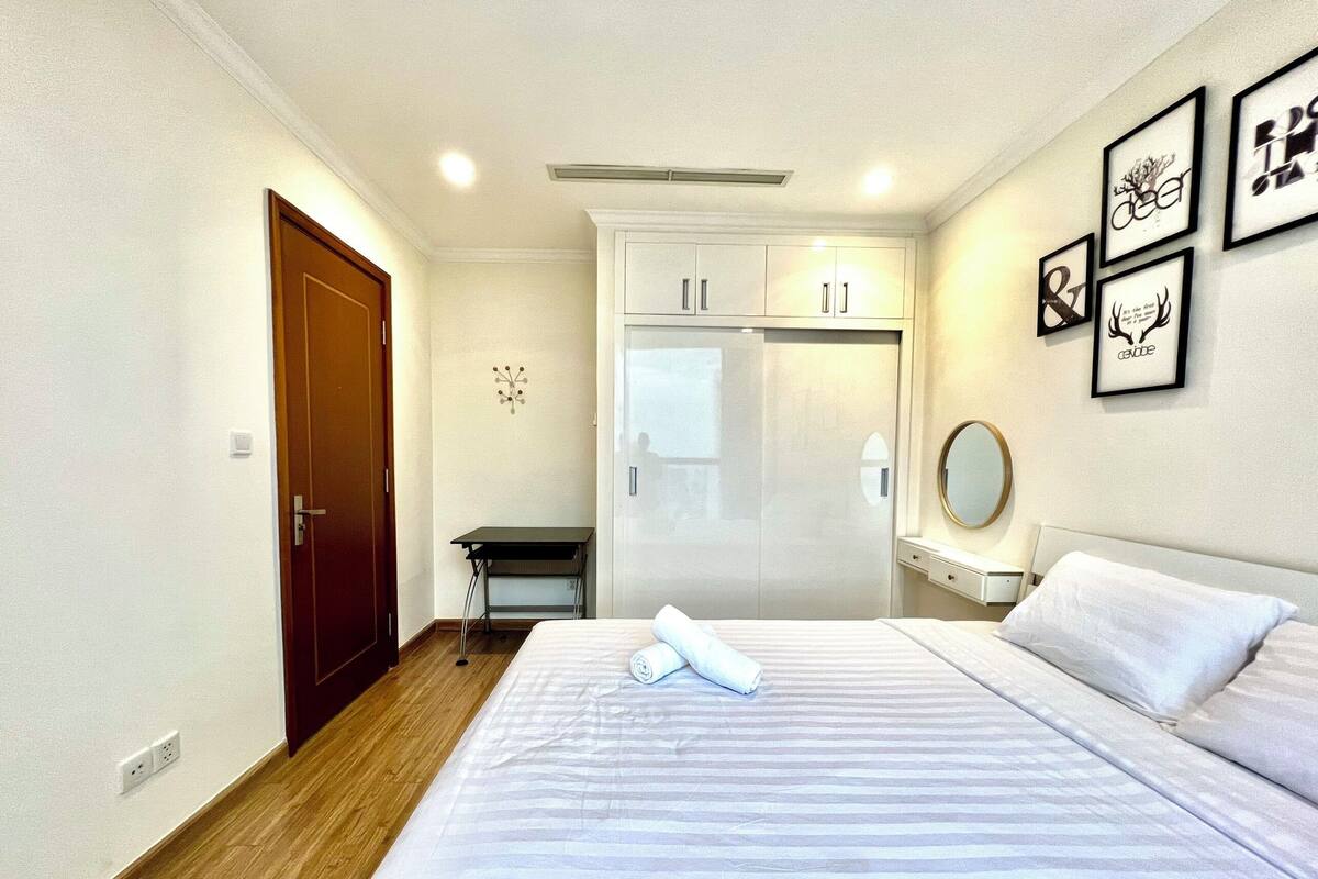 Ein Hotelzimmer mit Bett, Schreibtisch, Kleiderschrank und Spiegel.
