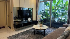 Una sala moderna con un televisor de pantalla plana grande, un reloj y una mesa de centro.
