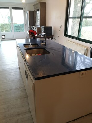 A modern kitchen with a black countertop, stainless steel sinks, and a built-in oven. - Large family home with outdoor pool in the countryside. Pets allowed (Nort-sur-Erdre)