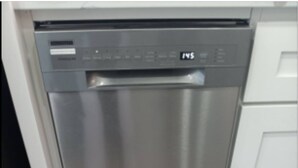 A stainless steel dishwasher in a kitchen with white cabinets.