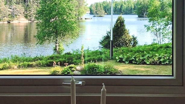 A window with a view of a lake and greenery. - 5 Person Holiday Home in Karlskoga (Karlskoga)