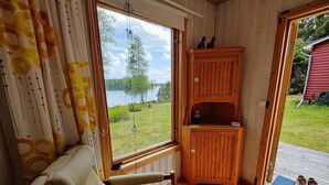 A cozy room with a large window, a wooden cabinet, and a chair. - 5 Person Holiday Home in Karlskoga (Karlskoga)