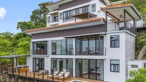A modern multi-story house with a pool, large windows, and a balcony. -  Luxury Ocean View Villa-Private Heated Pool & Peloton Gym - Daily Housekeeping (Playa Hermosa)