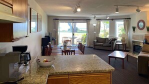 Amplia sala de estar con cocina, mesa de comedor y asientos.