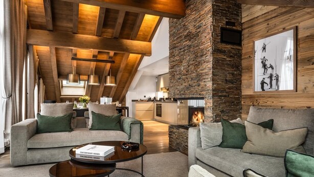 A modern living room with a stone fireplace, wooden beams, and a cozy seating area. - Wifi, 4th floor, view mountain, sauna, hammam, balcony, fireplace or stove, tv, 148m², Méribel (Méribel - Les Allues)