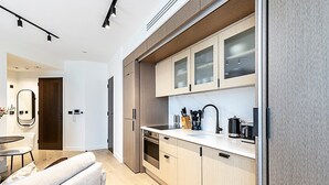 A modern kitchen with light wood cabinets, a white countertop, and stainless steel appliances. - Elegant Flat in Notting Hill's Heartbeat (London)