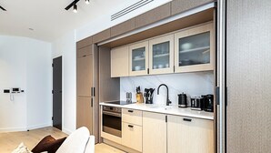A modern kitchen with light wood cabinets, a stainless steel oven, and a white countertop. - Elegant Flat in Notting Hill's Heartbeat (London)