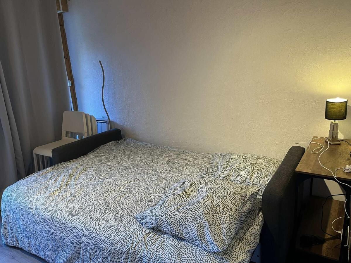 Une chambre d’hôtel avec un lit, un bureau doté d’une lampe et une chaise.