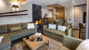 Un salon moderne avec deux canapés verts, une table basse en bois et une cheminée.