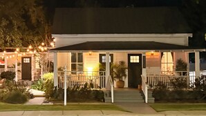 A building with a porch, outdoor seating, and string lights. - Walk to town and beach (Ocean Springs)