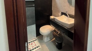 Ein kleines Badezimmer mit Toilette, Waschbecken und Duschbereich.