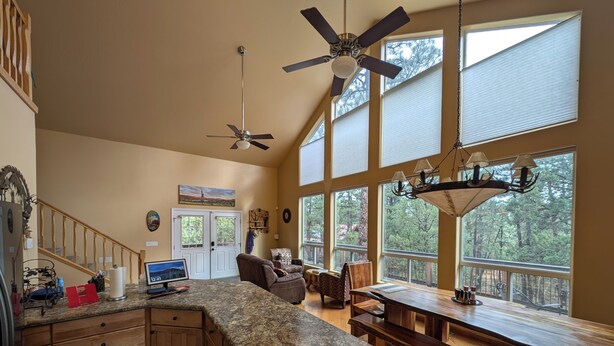 A spacious kitchen with a large island, wooden cabinets, and a dining area with a view of the forest. - HIDDEN SPACIOUS 4-bdr RETREAT FOR FAMILIES AND FRIENDS!  (Show Low)