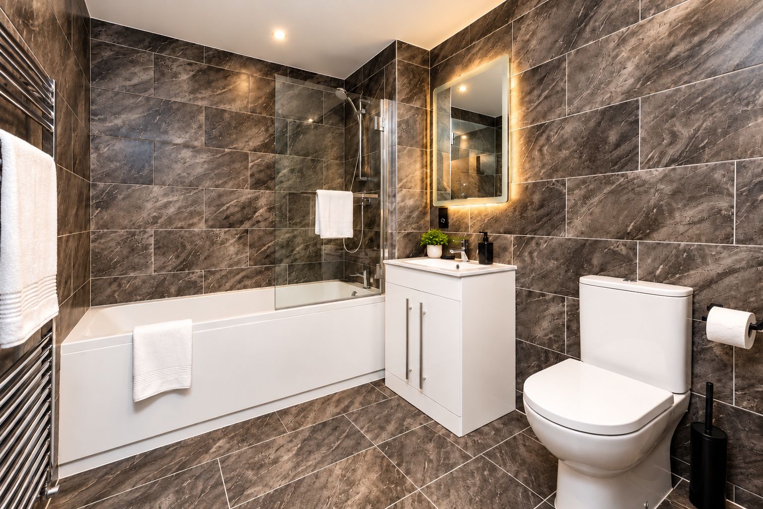 Ein modernes Badezimmer mit Badewanne, Toilette und Waschtisch.
