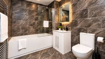 Ein modernes Badezimmer mit Badewanne, Toilette und Waschtisch.