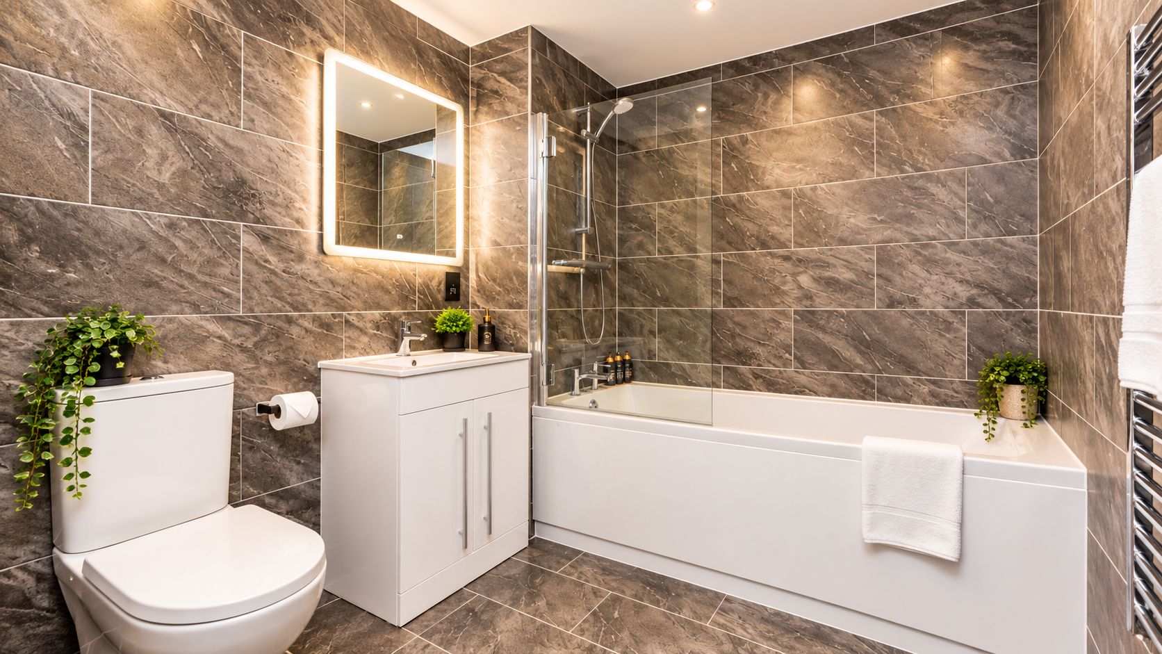 Ein modernes Badezimmer mit Toilette, Waschbecken und Badewanne.