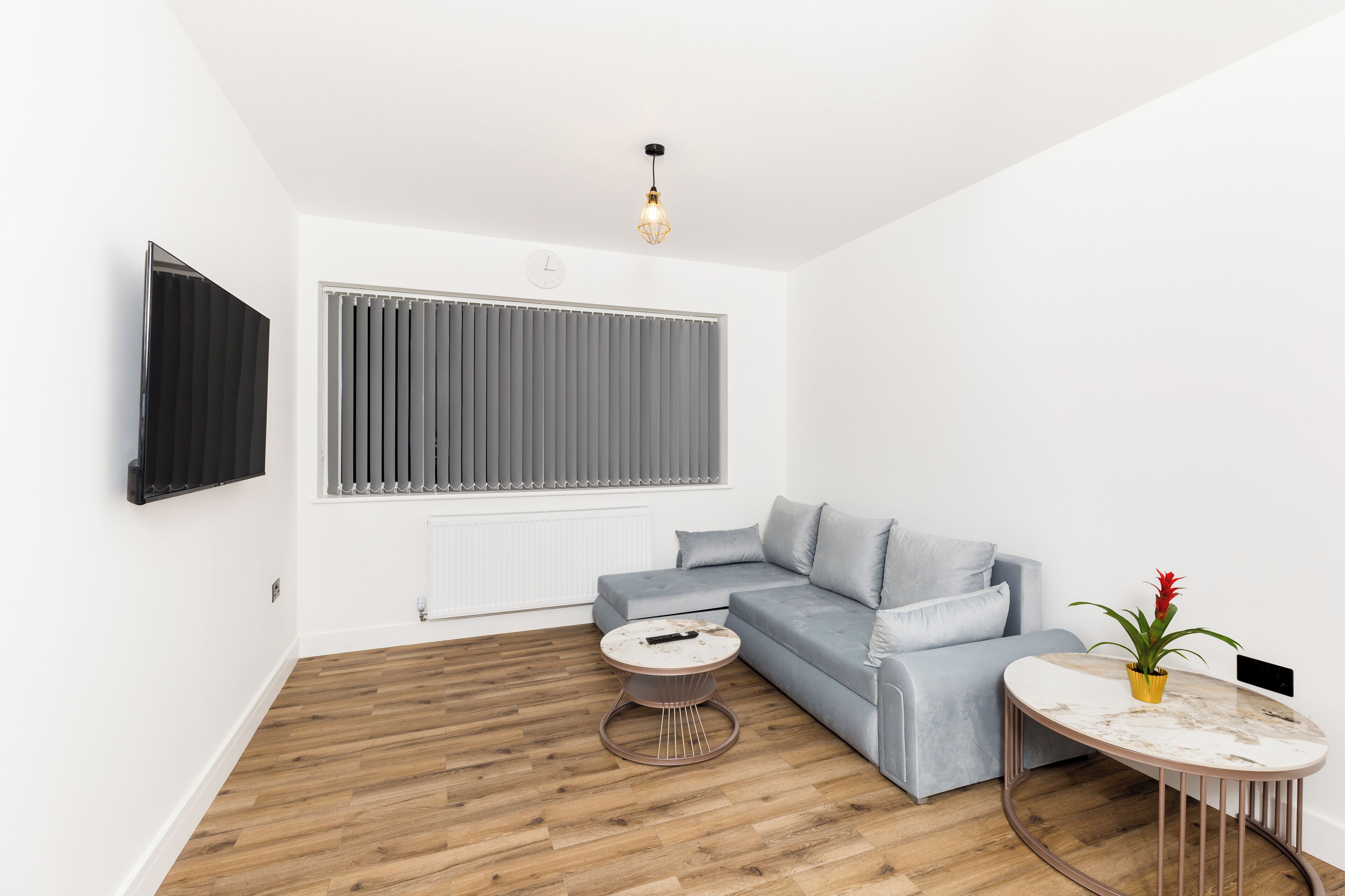 A modern living room with a grey sofa, a round coffee table, and a small side table.