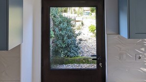 Ein Zimmer mit einer Glastür und einer eingebauten Klimaanlage darüber, sowie hellblauen Schränken.