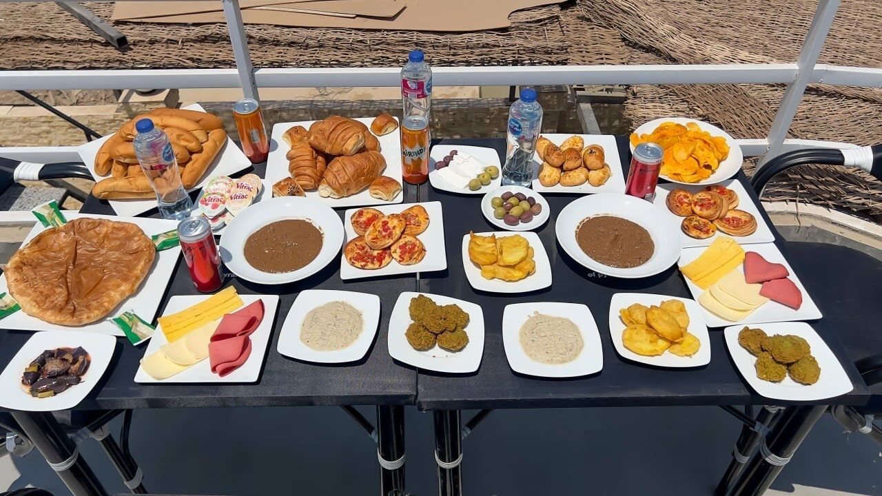 Ein Tisch mit verschiedenen Speisen und Getränken, vermutlich für eine Mahlzeit oder ein Treffen vorbereitet.