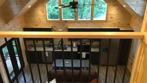 A loft-style room with a kitchen area, a dining table, and a seating area with a couch.