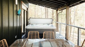A hot tub on a wooden deck with a glass table and wicker chairs. - Cedar Ridge Red River Gorge HotTub WiFi (Campton)