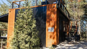 Een chalet met een houten gevel, een metalen dak en een bord met de naam 'Dark Skies'.