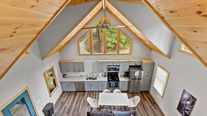 A loft-style room with a kitchen, dining area, and seating.