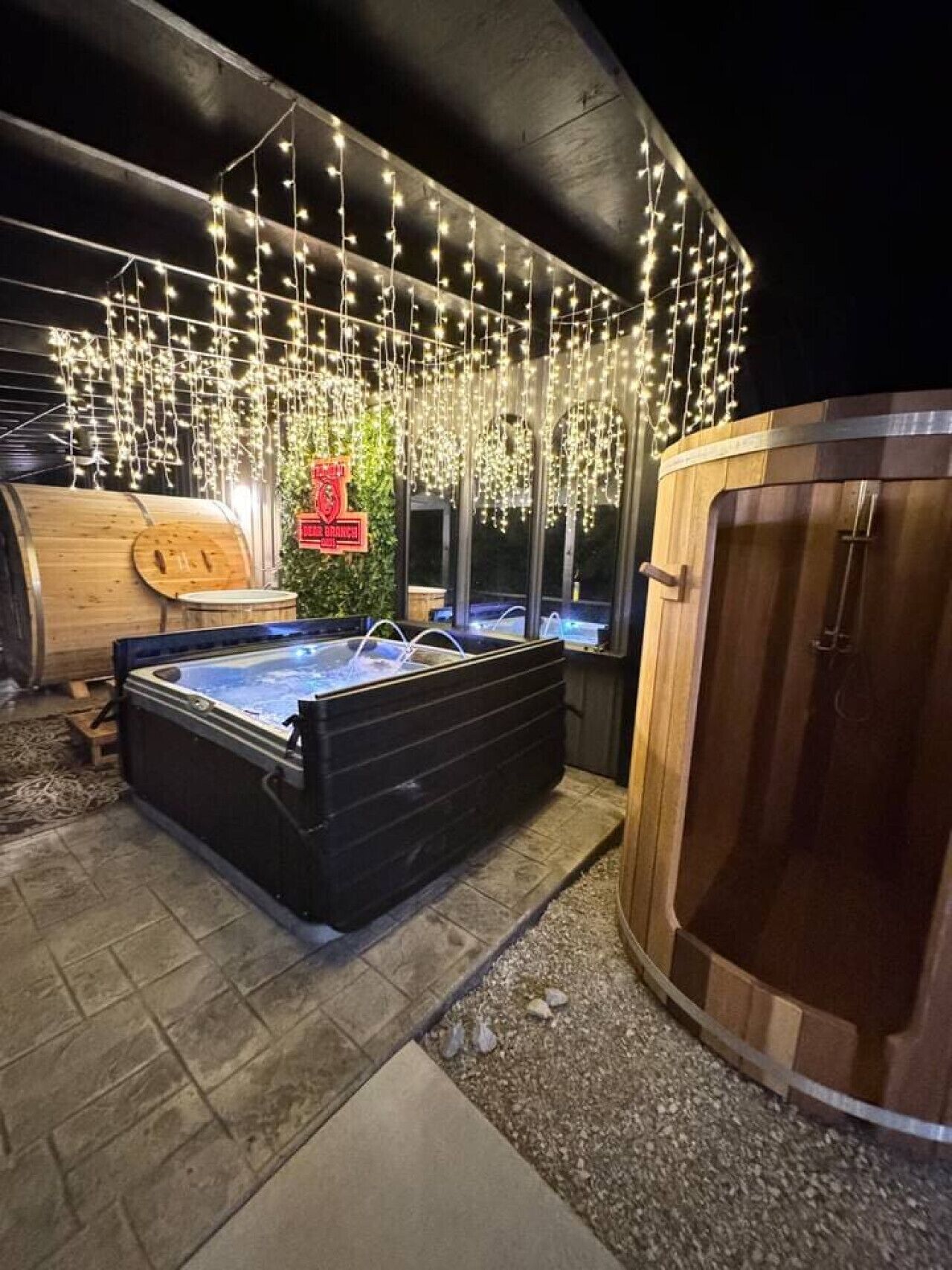 A hot tub area with a wooden barrel and a wooden sauna.