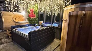 A hot tub area with a wooden barrel and a wooden sauna.