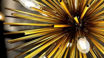 A chandelier with multiple light bulbs and golden metallic arms.