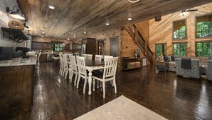 A spacious wooden interior with a dining area, kitchen, and living space.