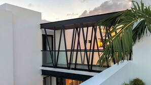 Een modern gebouw met een glazen balkon en een trap.