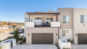 A modern two-story house with a garage, a balcony, and a driveway. - Hukilau House - St. George 5 Bedroom Townhouse (St. George)
