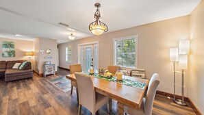 A spacious living room with a wooden dining table, comfortable seating, and a decorative ceiling light. - Tee Time On Breezemont 3 Bedroom Home (Sarasota)