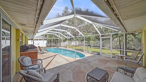 A covered outdoor area with a pool, wicker furniture, and a grill. - Tee Time On Breezemont 3 Bedroom Home (Sarasota)