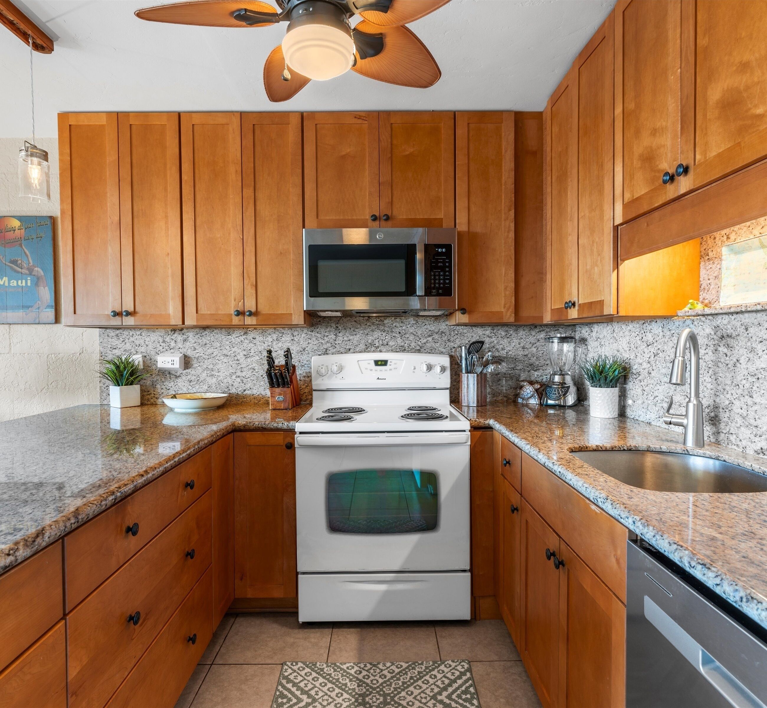A kitchen with wooden cabinets, a microwave, stove, and granite countertops.