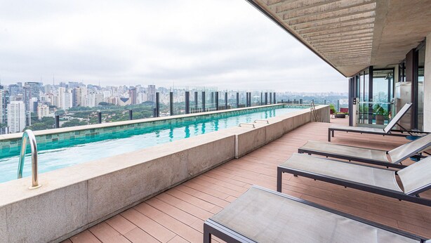 A rooftop pool with a city view, lounge chairs, and a concrete ceiling. - Apartamentos com vista incrível para São Paulo ao lado da Rebouças e Faria Lima - Pinheiros (São Paulo)