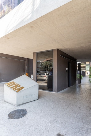 A concrete structure with a white box labeled 'SKR 2028' and a metal grate on the ground. - Apartamentos com vista incrível para São Paulo ao lado da Rebouças e Faria Lima - Pinheiros (São Paulo)
