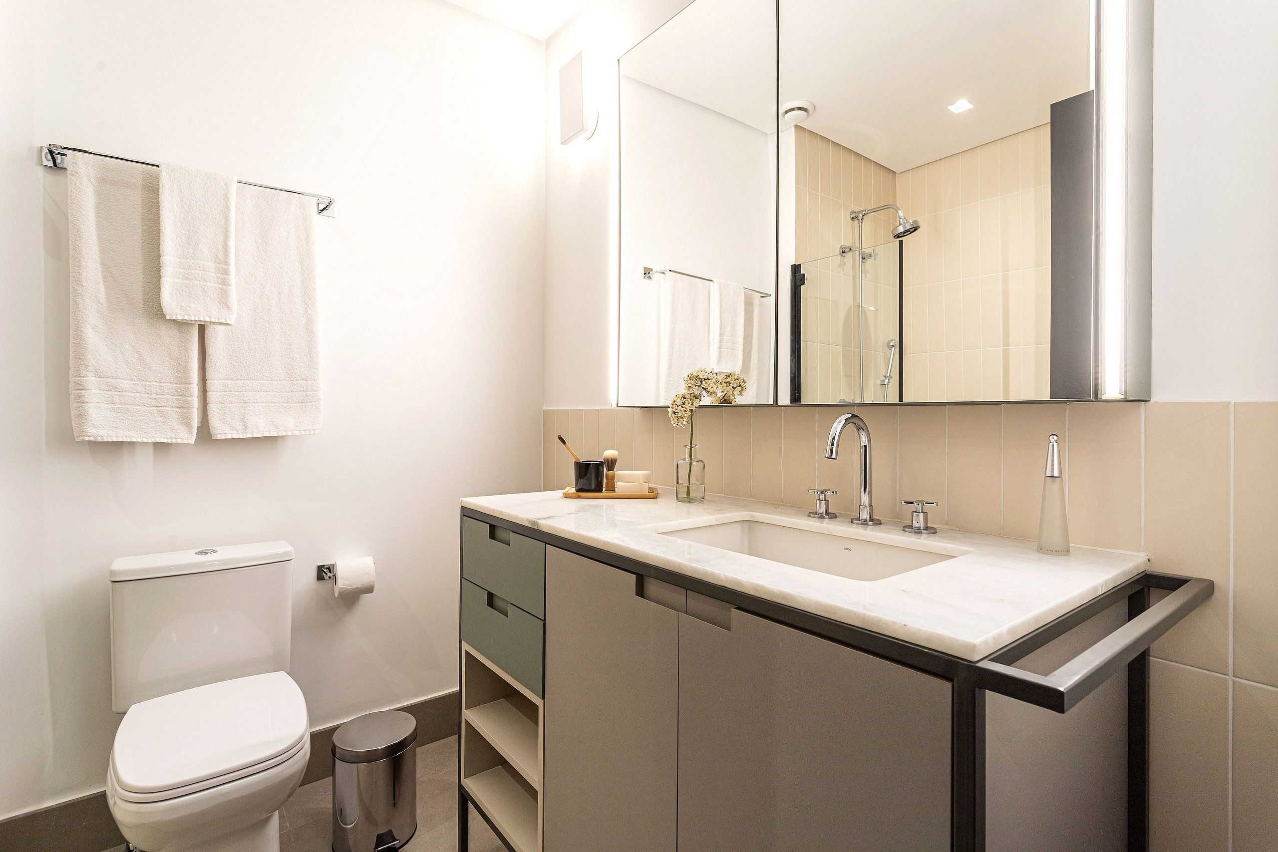 Un bagno moderno con il water, un lavandino e uno specchio.