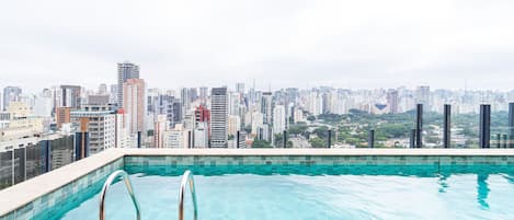 Une piscine sur le toit offrant une vue sur le paysage urbain.