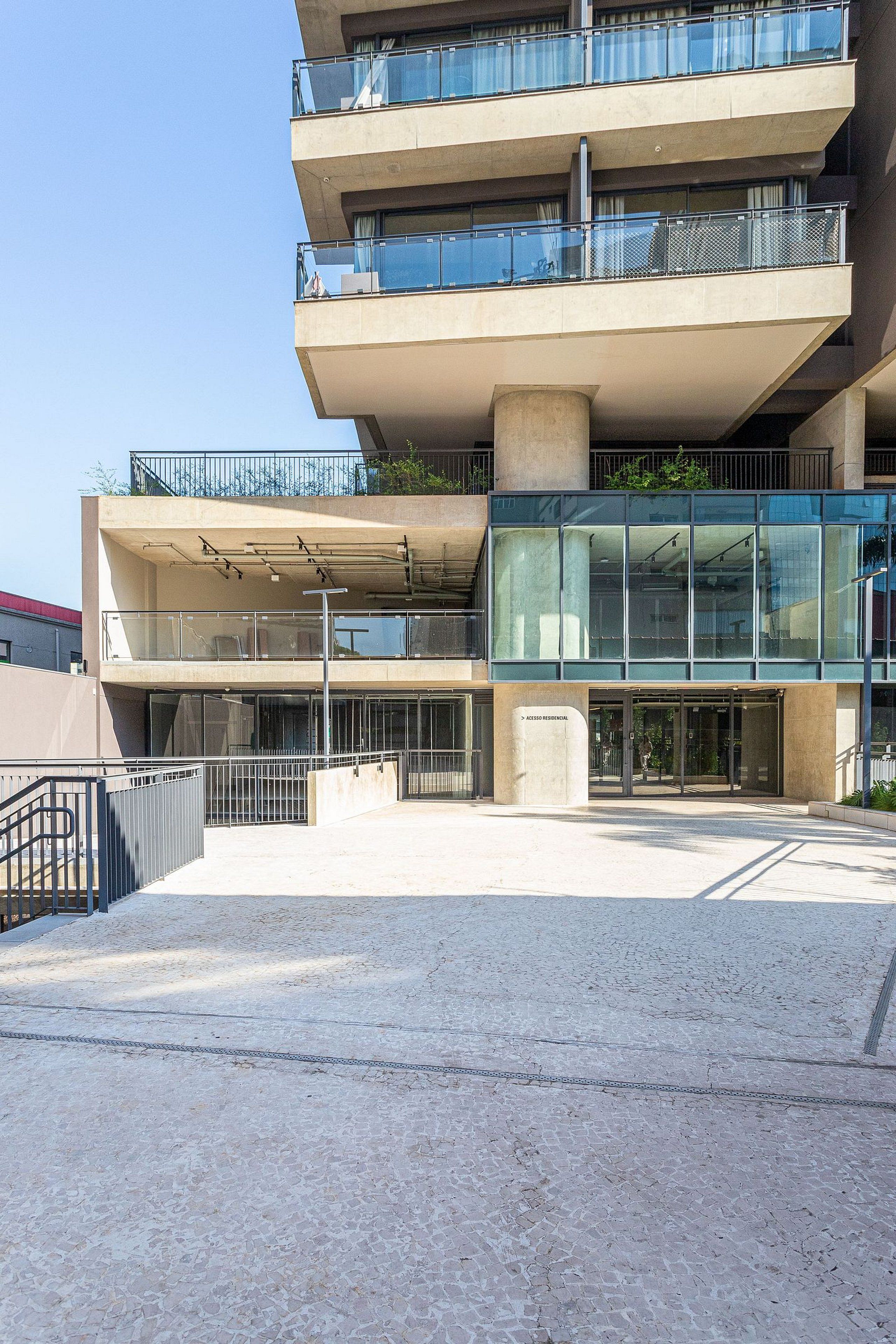 A multi-story building with balconies, large windows, and a gated entrance.