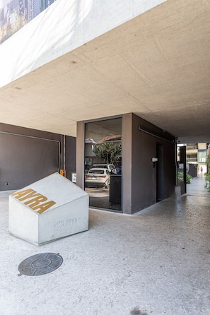 A concrete structure with a white box labeled 'SKR 2028' and a metal grate on the ground. - Apartamentos com vista incrível para São Paulo ao lado da Rebouças e Faria Lima - Pinheiros (São Paulo)