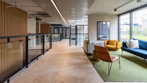 A modern interior with a long corridor, seating area with sofas and chairs, and large windows. - Apartamentos com vista incrível para São Paulo ao lado da Rebouças e Faria Lima - Pinheiros (São Paulo)