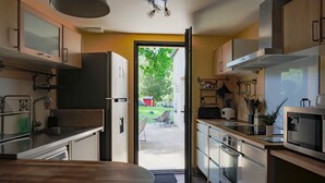 Eine moderne Küche mit Holzschränken, Edelstahlgeräten und Blick ins Freie.