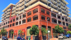 Un hôtel à plusieurs étages, avec une façade en briques rouges, de nombreux balcons et une enseigne indiquant « The Rockwell ».