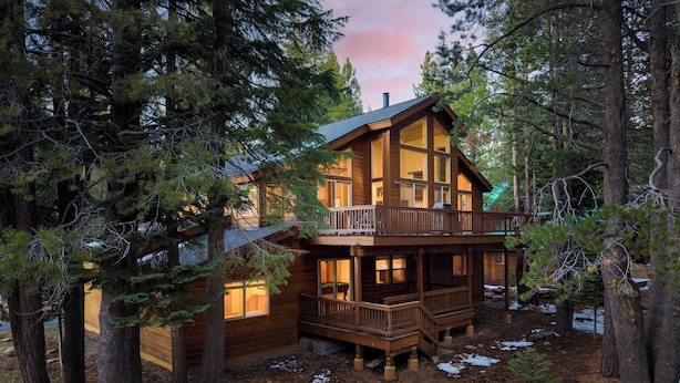 A cabin with a wooden exterior, a balcony, and a deck, surrounded by trees. - Hansel by Avantstay Pool Table, 5mins to Skiing (Truckee)